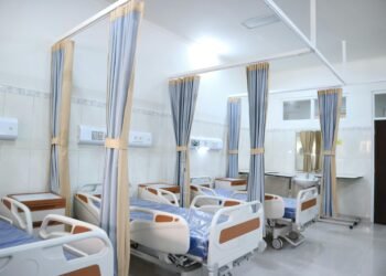 Spacious hospital ward with modern equipment and private patient areas.