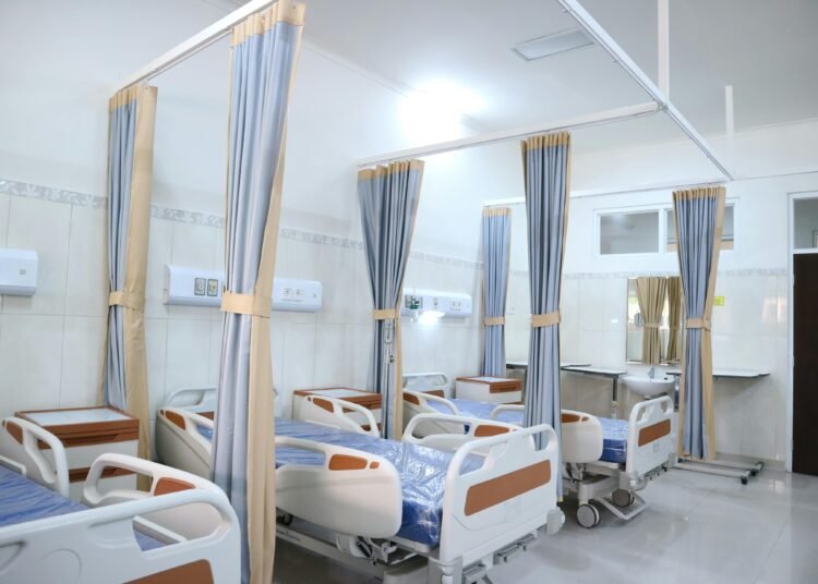 Spacious hospital ward with modern equipment and private patient areas.