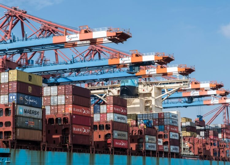 a large cargo ship loaded with containers under a blue sky