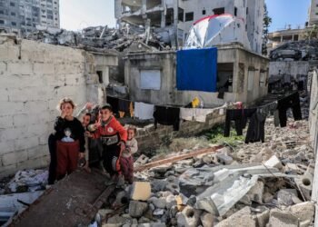 A group of people standing next to a pile of rubble