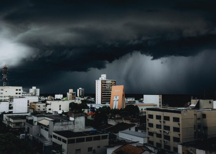 Dramatic storm clouds hover over city skyscrapers, creating a moody urban landscape contrast.