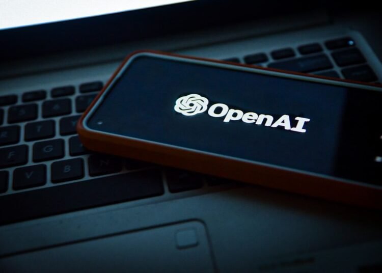 a cell phone sitting on top of a laptop computer
