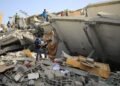 a group of people standing next to a collapsed building