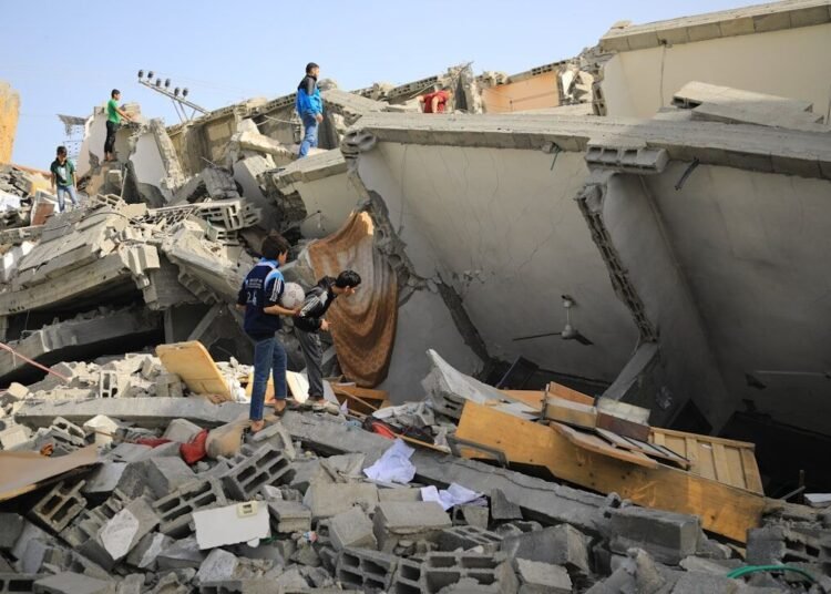 a group of people standing next to a collapsed building