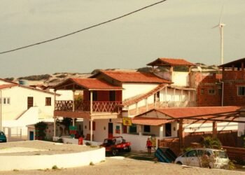 A picturesque view of traditional Brazilian beach houses under a clear sky.