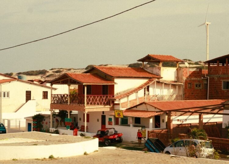 A picturesque view of traditional Brazilian beach houses under a clear sky.