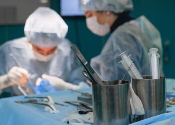 Focused surgeons in an operating room performing surgery with medical instruments.