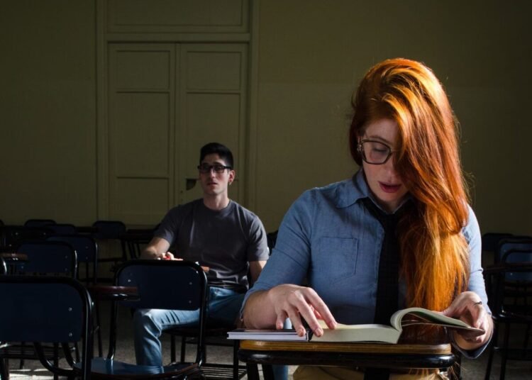 Two students study in a dimly lit classroom in Buenos Aires, Argentina.