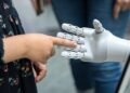 a person holding a robotic hand in front of a mirror