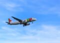 flying white and red airliner plane