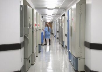 man in blue dress shirt walking on hallway