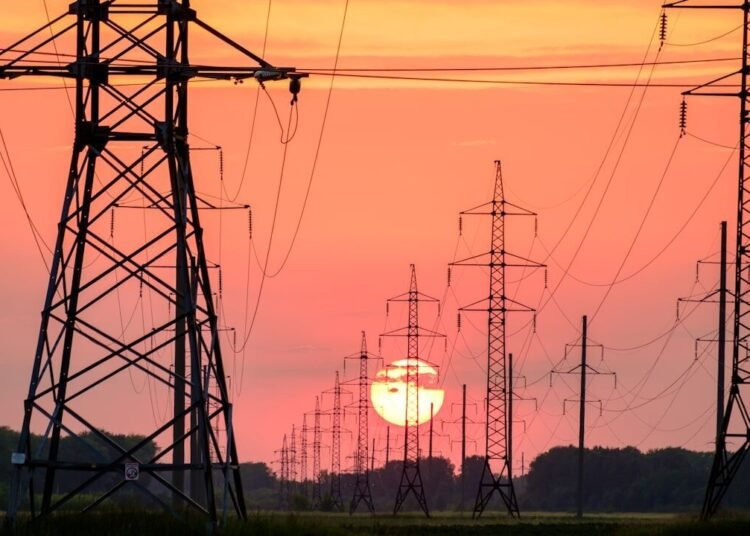 silhouette of electric post during sunset
