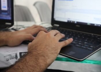 a man is typing on a laptop computer