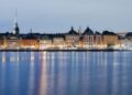 Beautiful twilight cityscape of Stockholm waterfront with historic buildings reflected in calm waters.