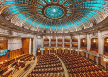 Vibrant interior of a parliament hall with a grand dome and intricate architecture.